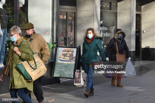 People wearing face masks leave a Marks and Spencer store on the High Street on November 29, 2021 in Brentwood, England. Six cases of people with the...