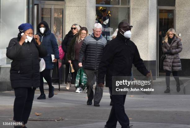 Members of the public, some wearing face masks walk past a Marks and Spencer store on the High Street on November 29, 2021 in Brentwood, England. Six...