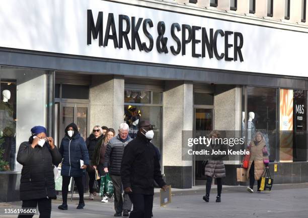 Members of the public, some wearing face masks walk past a Marks and Spencer store on the High Street on November 29, 2021 in Brentwood, England. Six...