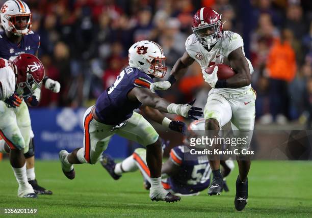 Brian Robinson Jr. #4 of the Alabama Crimson Tide rushes against Zakoby McClain of the Auburn Tigers during the second half at Jordan-Hare Stadium on...