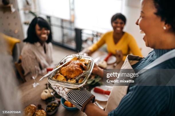 mujer sirviendo pavo asado a amigos en casa - servir comida y bebida fotografías e imágenes de stock