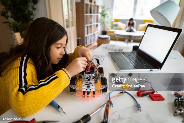 aluna focada, ajustando seu protótipo de um carro robótico autônomo auto-dirigido com chave de fenda - nerd girl - fotografias e filmes do acervo