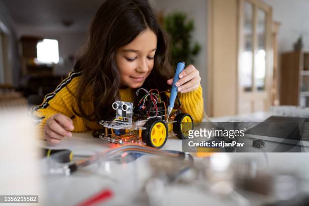 dedicated schoolgirl, repair her prototype of an autonomous self-driven robotic car with screwdriver - school science project stock pictures, royalty-free photos & images