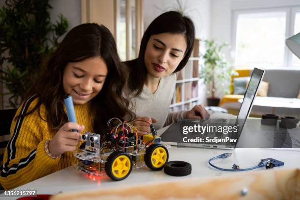 mãe caucasiana observando sua filha inteligente enquanto fazia um projeto de ciências escolares - projeto científico escolar - fotografias e filmes do acervo