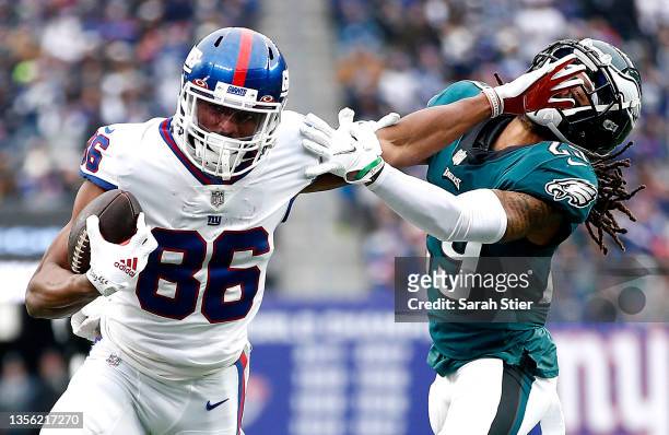 Darius Slayton of the New York Giants fends off a tackle attempt by Avonte Maddox of the Philadelphia Eagles in the third quarter at MetLife Stadium...