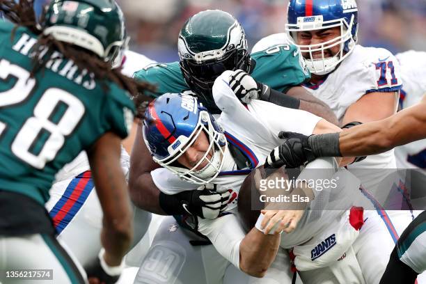 Fletcher Cox of the Philadelphia Eagles tackles Daniel Jones of the New York Giants in the third quarter at MetLife Stadium on November 28, 2021 in...