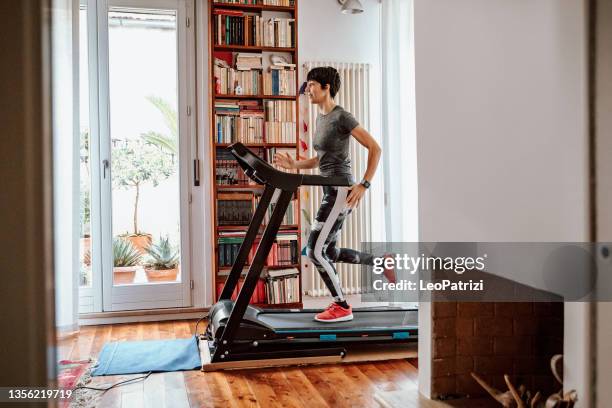 mujer entrenando en cinta de correr en casa - treadmill fotografías e imágenes de stock