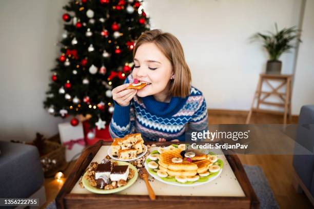 charming young woman enjoying the healthy and delicious breakfast - christmas breakfast stock pictures, royalty-free photos & images