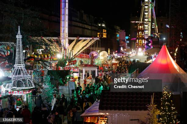 Visitors wearing protective face masks visit the Christmas market in Tuileries Garden during the coronavirus epidemic on November 29, 2021 in Paris...