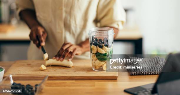 primer plano de manos de mujer cortando plátano en una tabla de cortar - licuadora fotografías e imágenes de stock