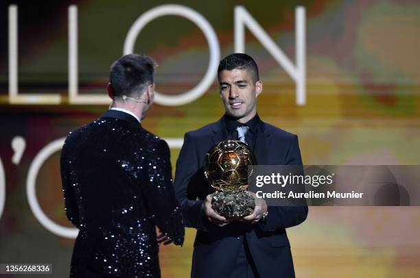 Luis Suárez awards Lionel Messi with the Ballon d'Or Trophy during the Ballon D'Or ceremony at Theatre du Chatelet on November 29, 2021 in Paris,...