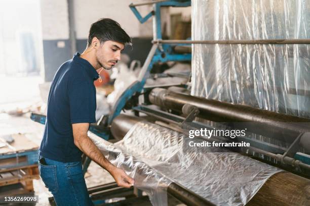 blue collar working on plastic recycling factory - plastic spool stock pictures, royalty-free photos & images