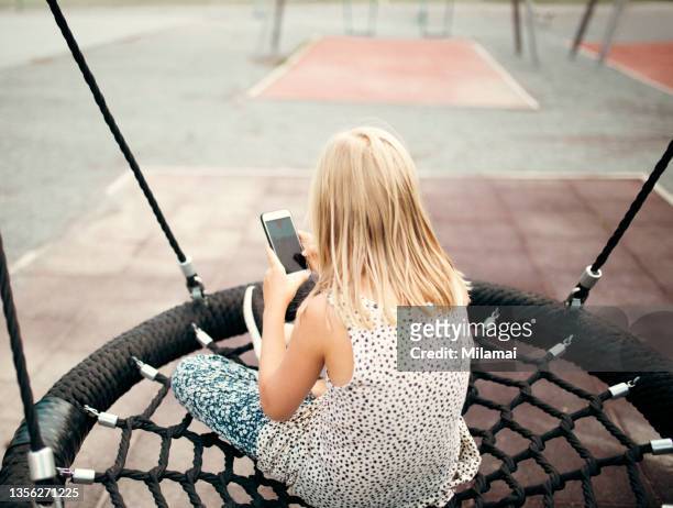 image of a young girl looking at her mobile phone - children on the internet stock pictures, royalty-free photos & images
