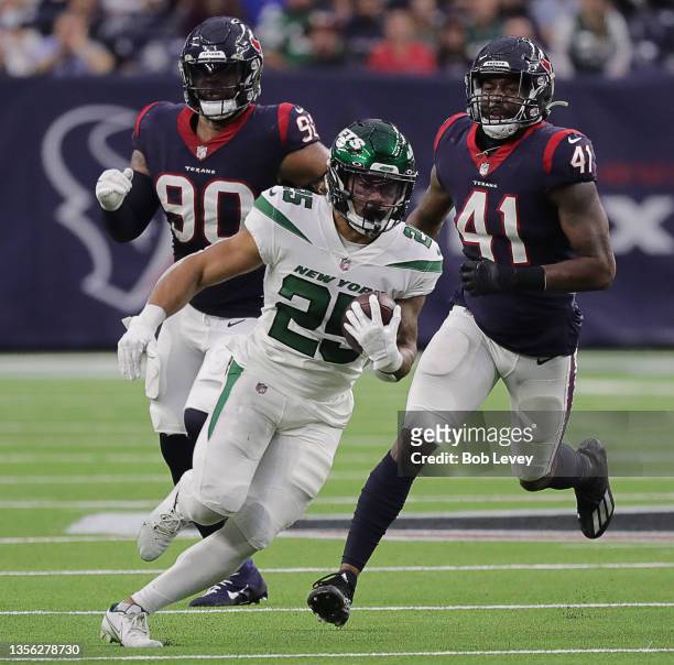 Ty Johnson of the New York Jets rushes as Zach Cunningham of the Houston Texans and Tavierre Thomas pursues at NRG Stadium on November 28, 2021 in...