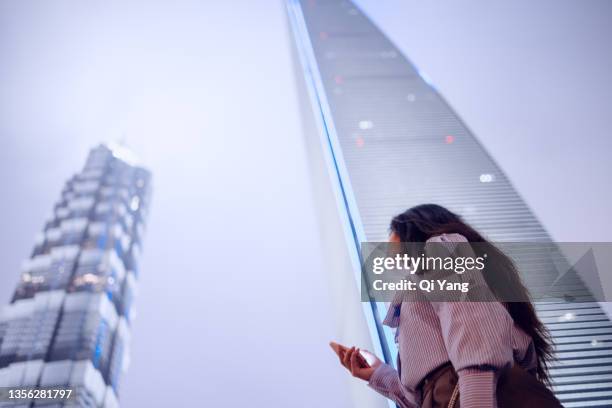 young asian business woman using smartphone in famous landmark of pudong district, shanghai - shanghai calling stock pictures, royalty-free photos & images