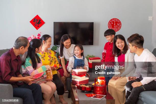 mehrgenerationen-familie gatheirng während chinense neujahr, sitzen auf dem sofa im wohnzimmer. - chinese new year food stock-fotos und bilder