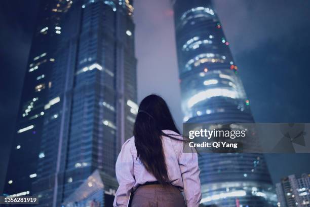 confident young asian woman standing in the financial district looking away, shanghai, china - work gender equality stock pictures, royalty-free photos & images