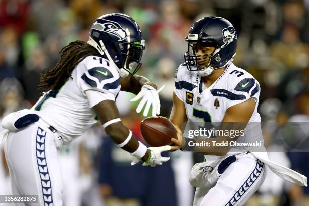 Russell Wilson of the Seattle Seahawks hands the ball off to teammate Alex Collins in the first quarter against the Washington Football Team at...