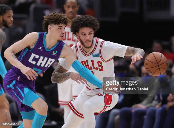 LaMelo Ball of the Charlotte Hornets and brother Lonzo Ball of the Chicago Bulls chase a loose ball at United Center on November 29, 2021 in Chicago,...