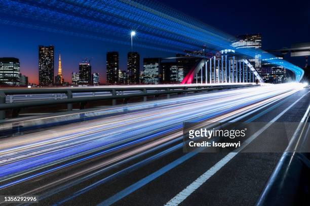 light trails against tokyo city skyline at twilight - tokyo skyline sunset stock pictures, royalty-free photos & images