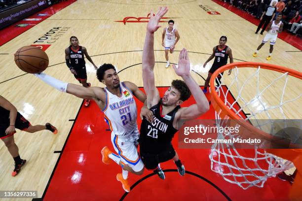 Aaron Wiggins of the Oklahoma City Thunder dunks the ball over Alperen Sengun of the Houston Rockets during the second half at Toyota Center on...