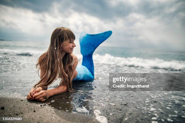 happy little mermaid at the beach - fantasy mermaid stock pictures, royalty-free photos & images