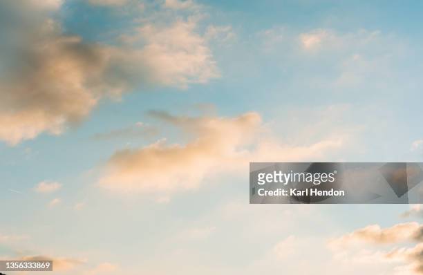 a view of pink clouds against a blue sky at sunset - stock photo - dusk stock pictures, royalty-free photos & images