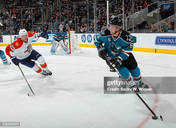 Defenseman Colin White of the San Jose Sharks skates with the puck against left wing Sean Bergenheim of the Florida Panthers at the HP Pavilion on...