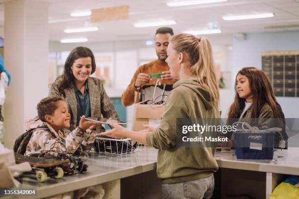 smiling boy exchanging digital tablet at recycling center - circulaire economie stockfoto's en -beelden