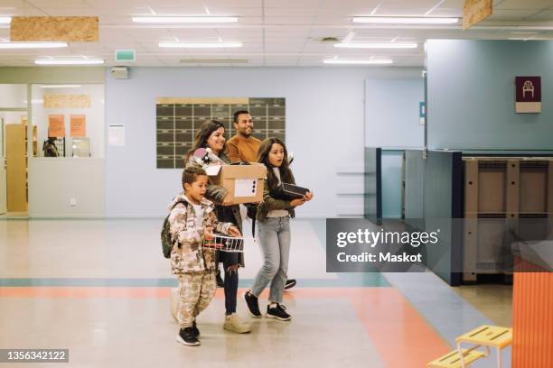 family carrying e-waste while walking in electronics industry - e waste stock pictures, royalty-free photos & images