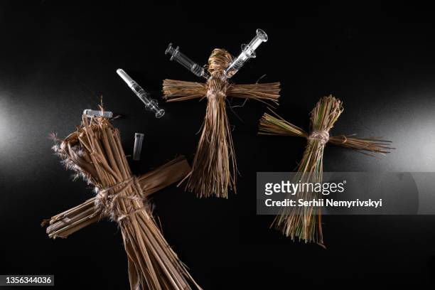 voodoo dolls and syringes on a black background. people management concept. compulsory vaccination. drugs and medicine. ritual and conspiracy. - wicca stock-fotos und bilder