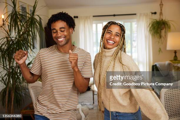 young couple laughing and dancing together at home - young couple dancing stock pictures, royalty-free photos & images