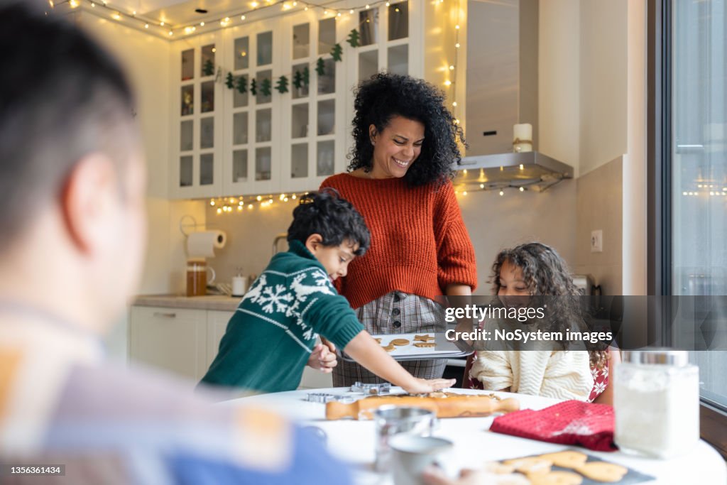 Sœur et frère faisant des biscuits au pain d’épices de Noël avec une mère