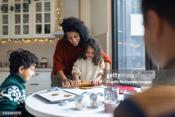 sister and brother making christmas gingerbread cookies with a mother - december 6 stock pictures, royalty-free photos & images