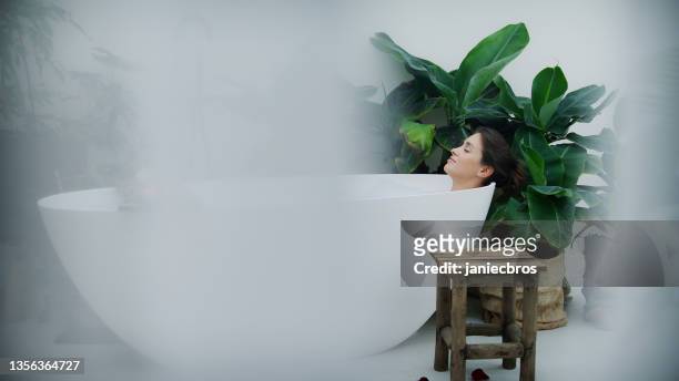 junge frau nimmt ein schaumbad im üppigen grünen garten in ihrem badezimmer. - beautiful woman bath stock-fotos und bilder