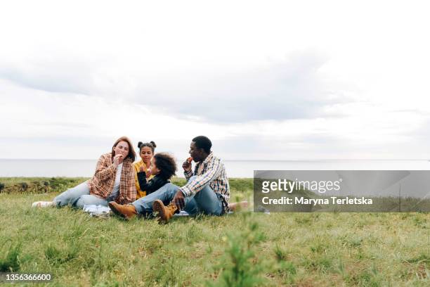 international family on a picnic overlooking the sea. - picnic stock pictures, royalty-free photos & images