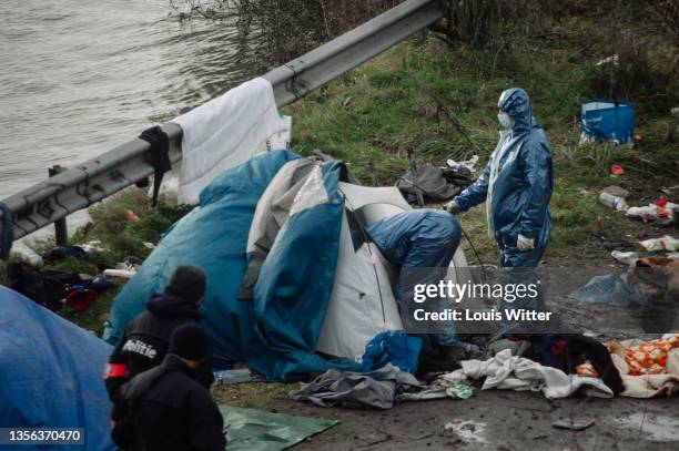 Cleaning team removes the tents of migrants in a make-shift camp during an eviction on November 30, 2021 in Grande-Synthe, France. As winter closes...