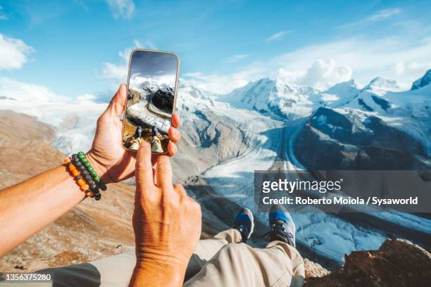 personal perspective of person photographing gorner glacier with smartphone, switzerland - travel stock-fotos und bilder
