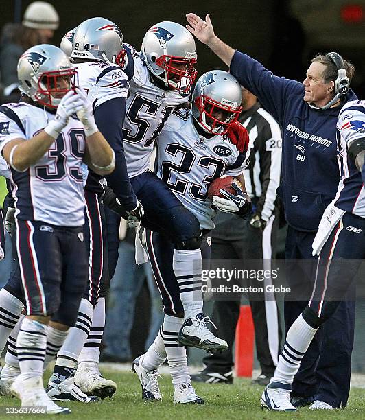 Patriots head coach Bill Belichick, right, gives linebacker Jerod Mayo a pat on the head for a job well done as he is carried off the field by...