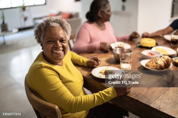 porträt einer seniorin während der kaffeepause mit freunden zu hause - humility stock-fotos und bilder