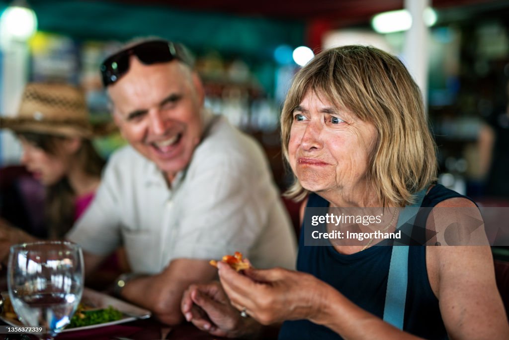 Ältere Frau probiert ein neues Gericht in einem Restaurant.