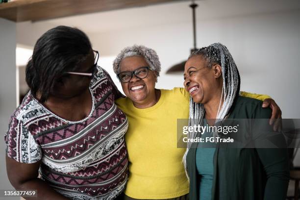 senior women embracing each other at home - older sibling stock pictures, royalty-free photos & images