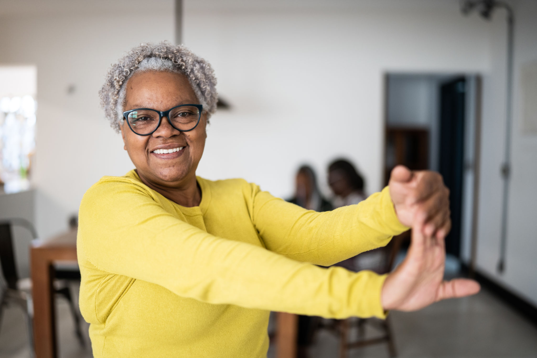 Portrait of a senior woman stretching her arms at home Portrait of a senior woman stretching her arms at home