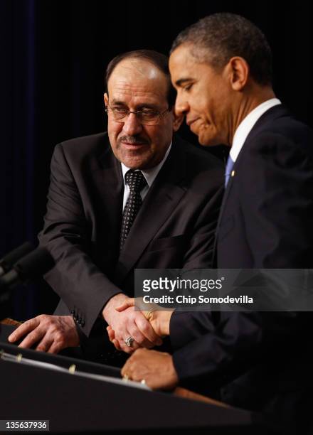 Iraqi Prime Minister Nouri Al-Maliki and U.S. President Barack Obama shake hands during a news conference in the Eisenhower Executive Office Building...