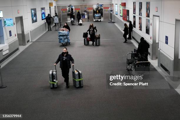 Travelers arrive from international flights, including from South Africa, at Newark Liberty International Airport on November 30, 2021 in Newark, New...