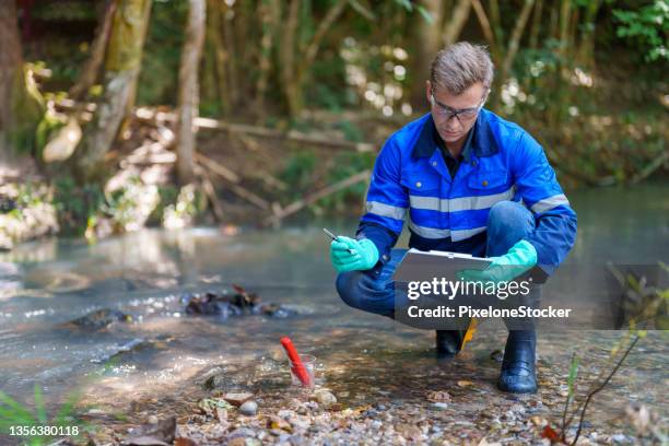 man using ph meter for measuring water quality in mountain river. - unit of measurement stock pictures, royalty-free photos & images