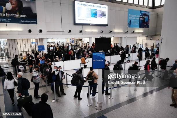 Travelers arrive for flights at Newark Liberty International Airport on November 30, 2021 in Newark, New Jersey. The United States, and a growing...