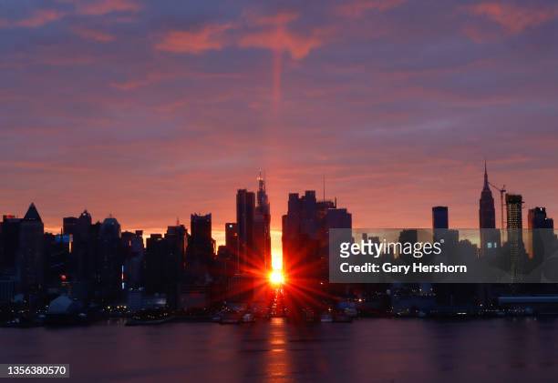 The sun rises above 42nd Street during a sunrise Manhattanhenge also known as reverse Manhattanhenge in New York City on November 30 as seen from...