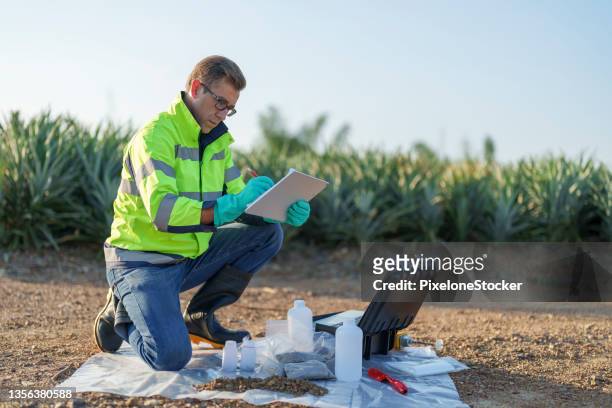 specialist technician working with soil sampling and measuring ,collecting and analysis data at the agriculture field. - prélèvement à tester photos et images de collection
