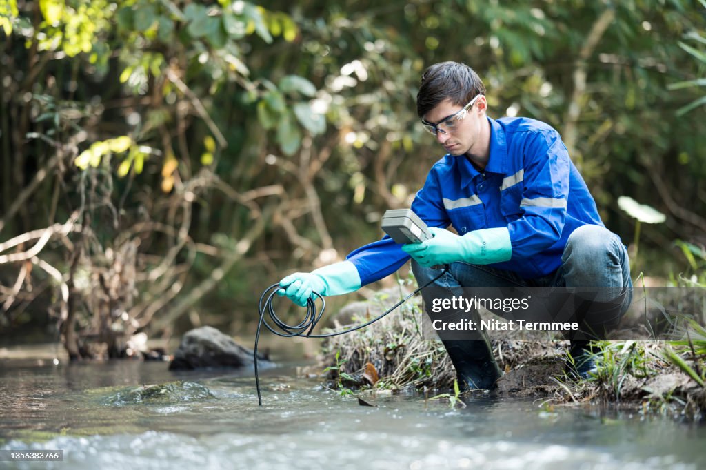 Biologists is measuring the pH of water by a micrometer from rivers or streams to research and development of drinking water resources r. Water sample, Environment issue.
